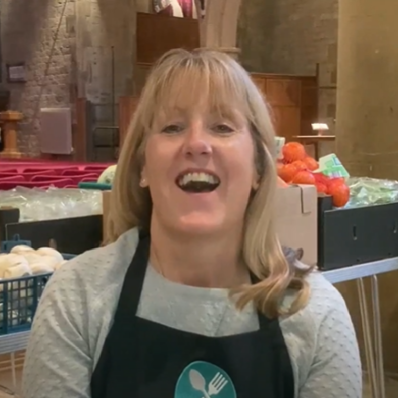 A smiling FEAST volunteer at a community larder