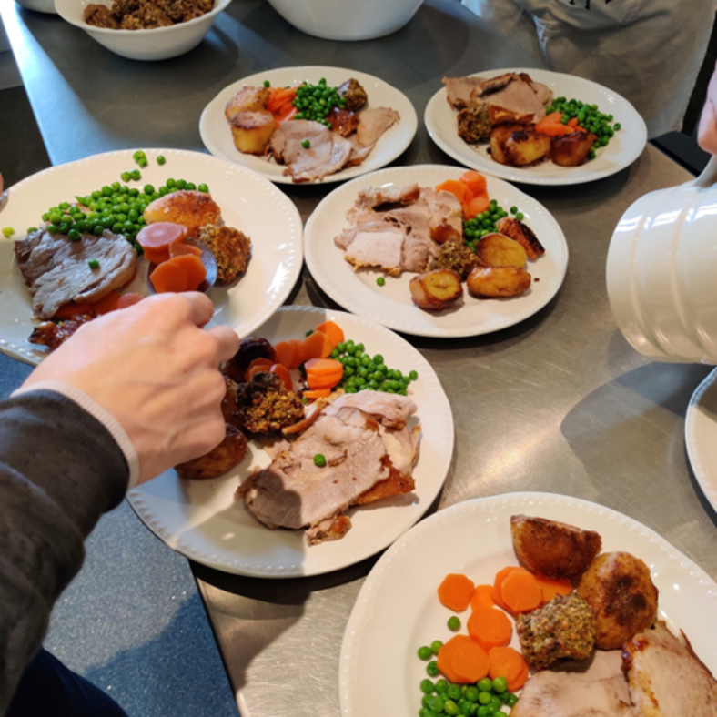 Six roast lunches being served onto plates