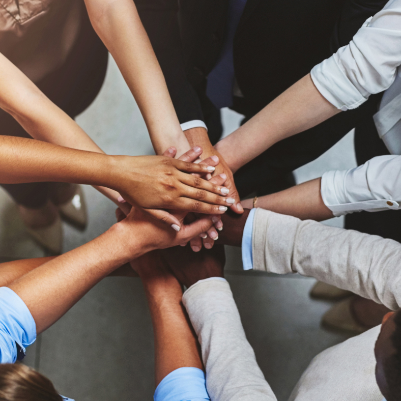 Four pairs of hands outstretched on top of each other