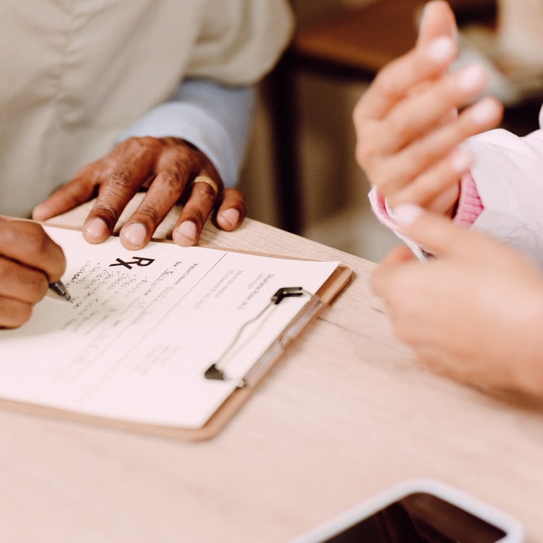 Hands of two people meeting and one writing.