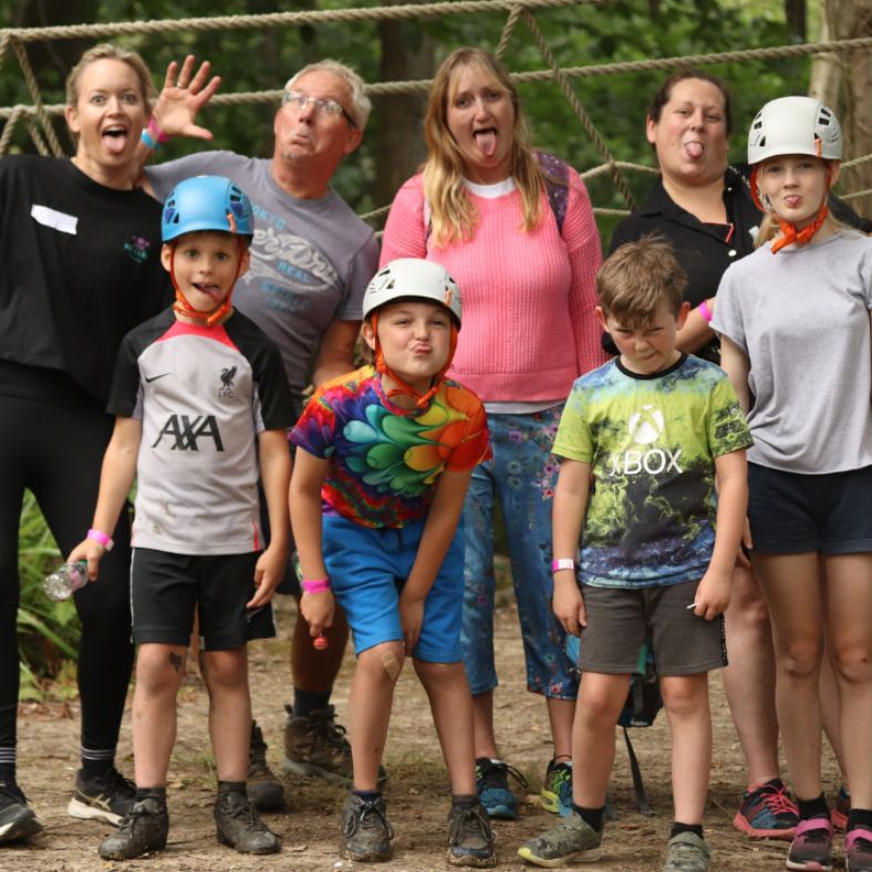 Group of adults and children outside pulling funny faces